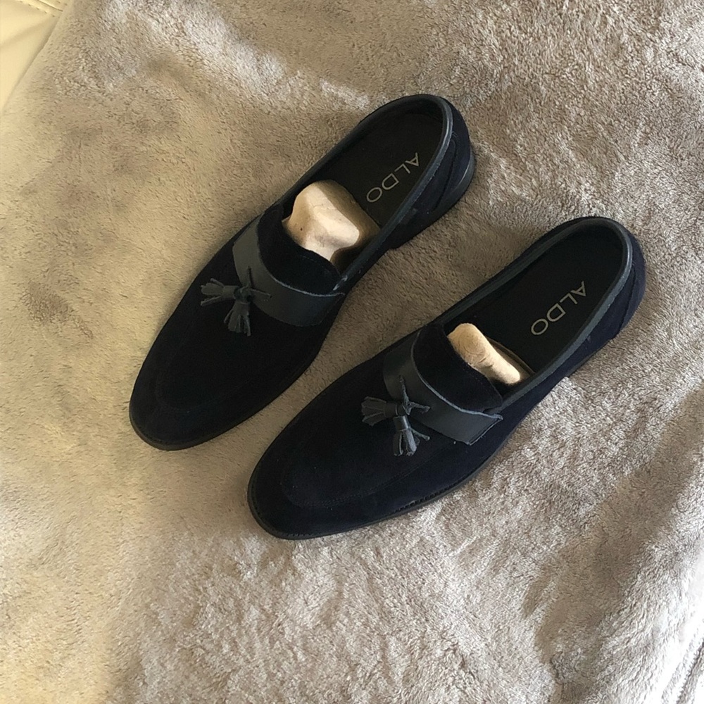 A pair of suede dark blue loafers .
